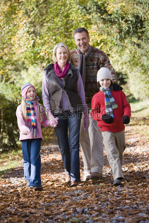 Grandparents and grandchildren on walk through autumn woods