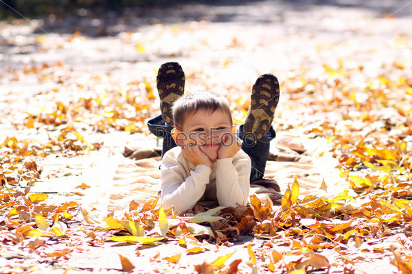 5 years old child lying on the golden leaf, stock photo