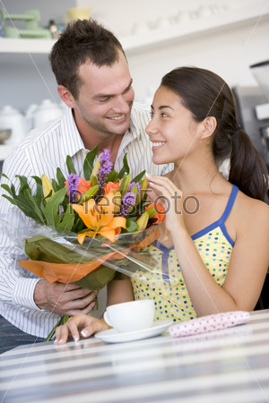 Молодой человек дарит девушке букет цветов