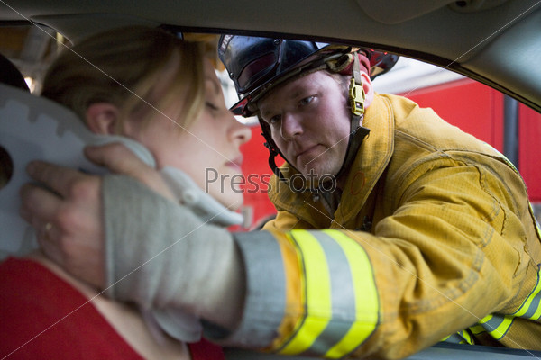 Fireman helping woman with neck brace (selective focus)