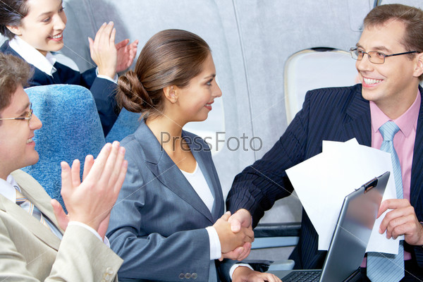 Photo of pretty woman handshaking with handsome partner after striking deal in airplane