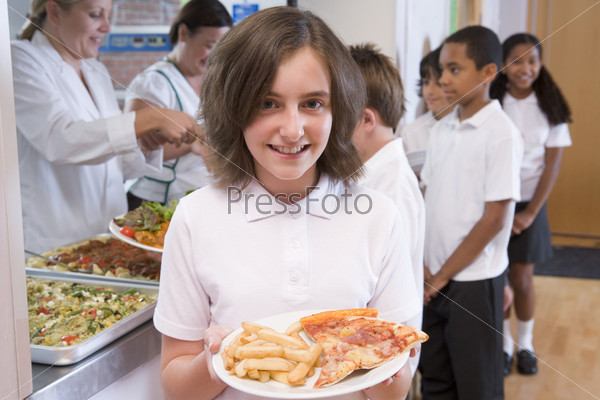 Students in cafeteria line with one holding unhealthy meal looking at camera