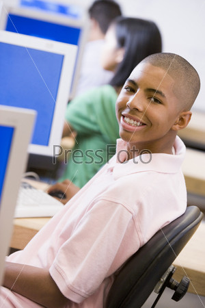 Schoolboy sitting in front of a computer