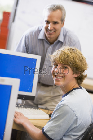 Teacher with male student in computer class