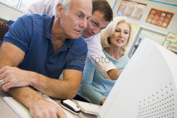 Male and female mature students working together on a computer