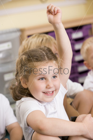 Ученица начальной школы поднимает руку