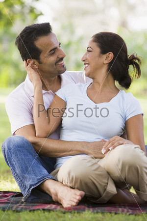Couple relaxing in park sitting on blanket