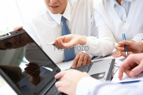 Businesswoman pointing at lcd screen while explaining something at meeting