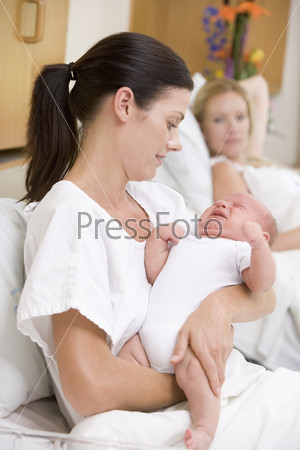New mother with crying baby in hospital