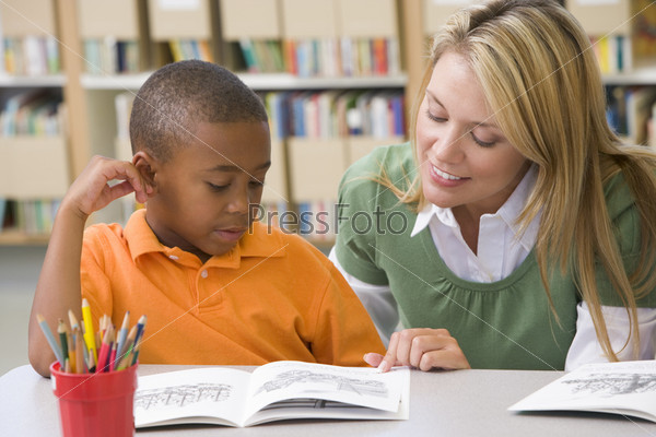 Teacher helping student with reading skills
