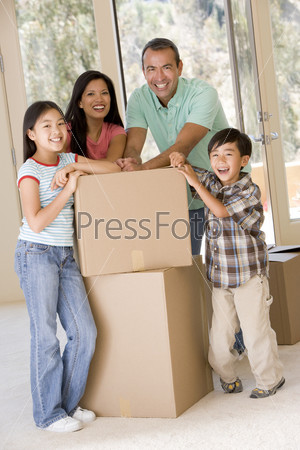 Family with boxes in new home smiling