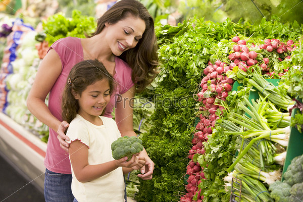 Mother and daughter shopping for fresh produce in supermarket
