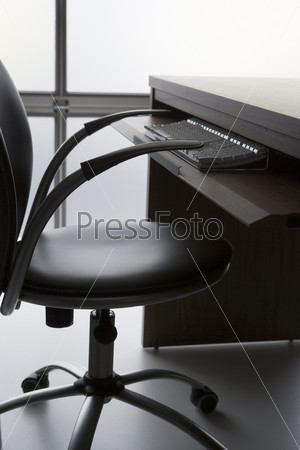Empty Office Chair And Desk With Computer Keyboard