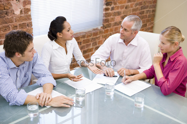 Four businesspeople in boardroom meeting