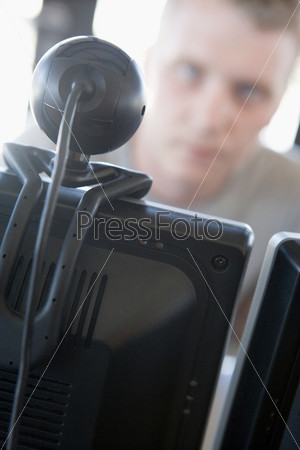 Shot of a man behind a computer and web camera