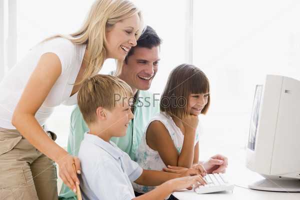 Family in home office using computer smiling