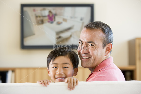 Man and young boy in living room with flat screen television smi