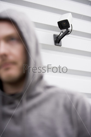 Surveillance Camera And Man In Hooded Sweatshirt