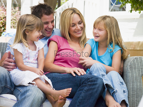 Family sitting on patio smiling