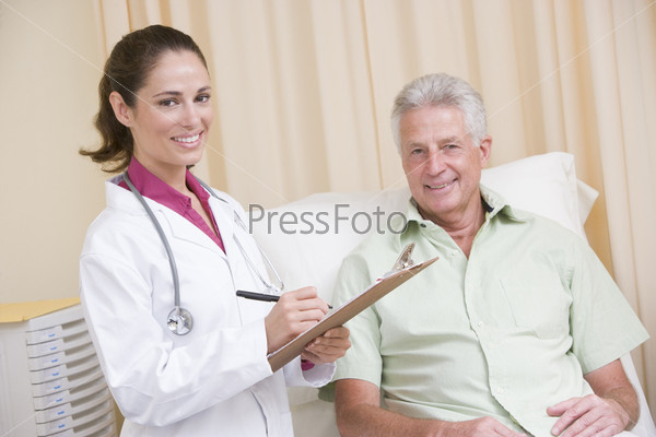 Doctor writing on clipboard giving checkup to man
