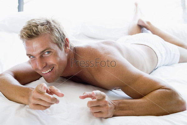 Man lying in bed pointing