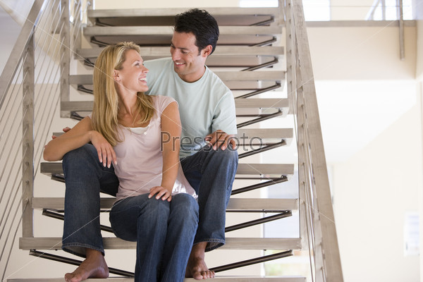 man and women sat on stairs indoors