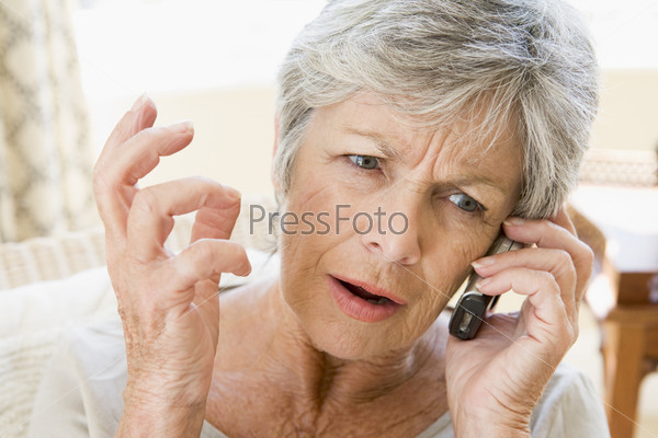 Woman indoors using cellular phone frowning