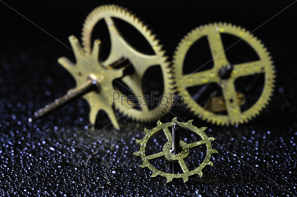The image of the cogs, wheels and gears of the inside of an old clock.