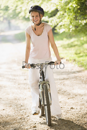 Счастливая молодая девушка, катающаяся на велосипеде