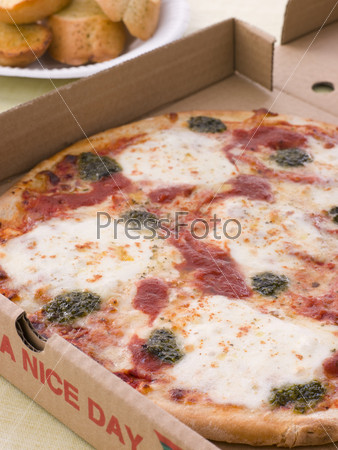 Cheese, Tomato And Pesto Pizza In A Take Away Box With Garlic Bread
