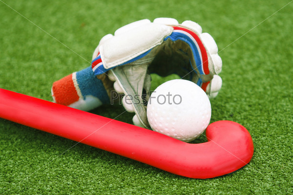 Glove with a red stick on green grass