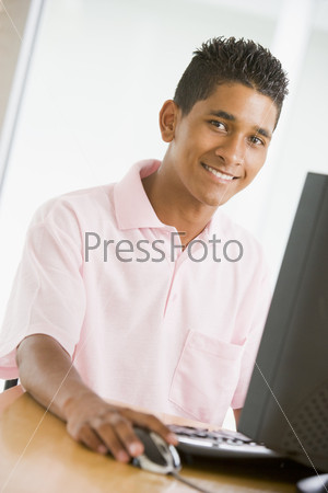 Парень-подросток сидит за компьютером