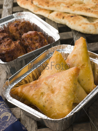 Индийские блюда на вынос: овощи самоса, хлеб Наан  и лук Бахджи