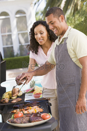 Семейная пара наслаждается барбекю в саду