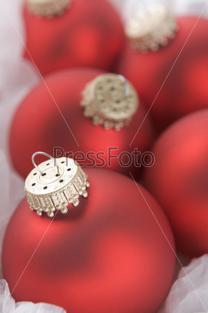Group of red christmas tree decorations wrapped in tissue paper