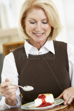 Пожилая женщина ест чизкейк