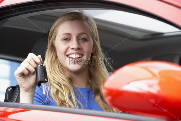 Teenage Girl Sitting In Car, Holding Car Keys And Smiling At The