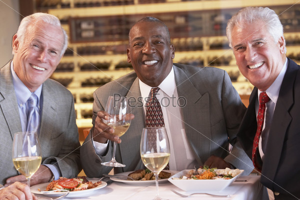 Пожилой счастливый мужчина-афроамериканец за обедом в кругу друзей 