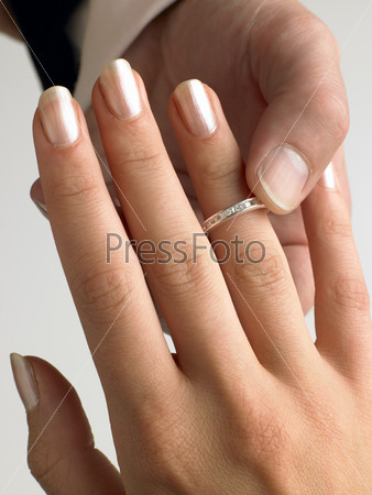 Man Putting Diamond Ring On Woman\'s Finger