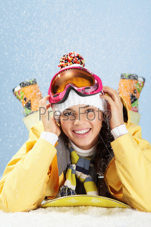 Портрет молодой девушки в горнолыжных очках на голубом фоне