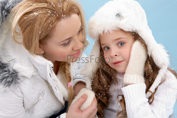 Portrait of mother and her daughter in warm winter clothes