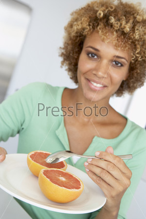 Mid Adult Woman Eating Fresh Grapefruit