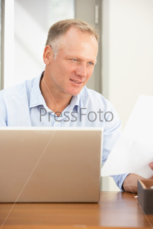 Мужчина работает за ноутбуком дома
