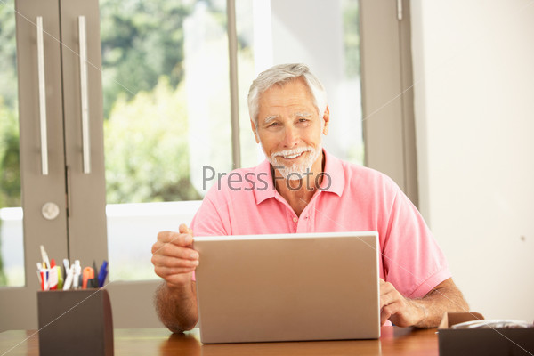 Пожилой мужчина работает на ноутбуке
