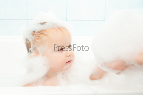cute adorable baby play with foam in bath
