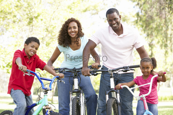 Молодая семья на велосипедах в парке