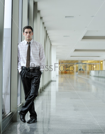 handsome young man in  business suit standing in  office environment