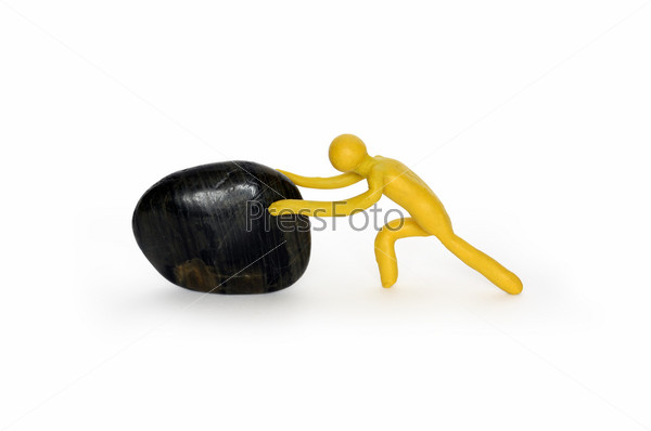 Yellow plasticine man pushing black stone. Isolated on white