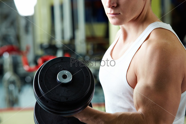 Close-up of sporty man training in gym with barbell