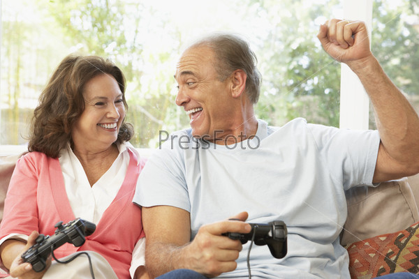 Senior Couple Playing Computer Game At Home
